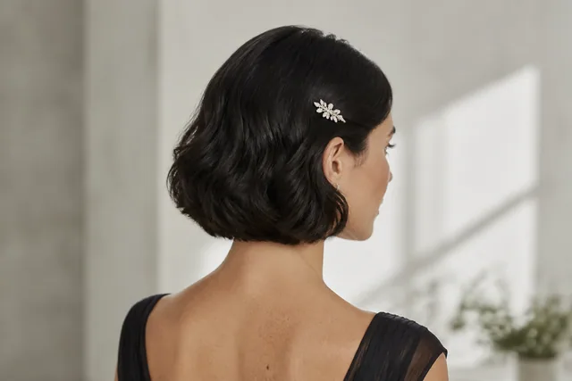 Illustratives festliches Styling eines kurzen Bobs mit weicher Seitenwelle und kleiner Schmuckspange